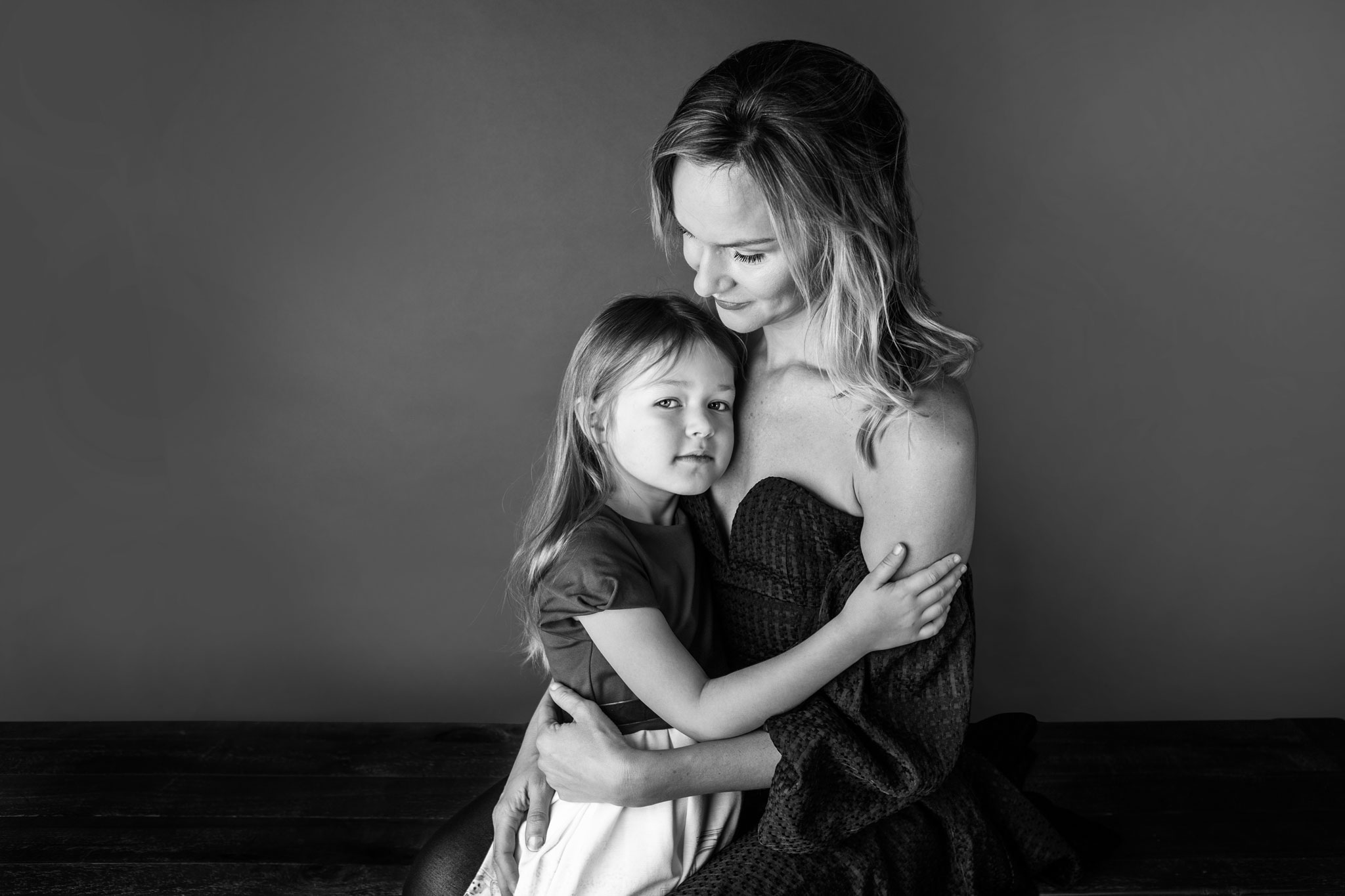 Studio portrait of mother and daughter embraced in eachother's arms
