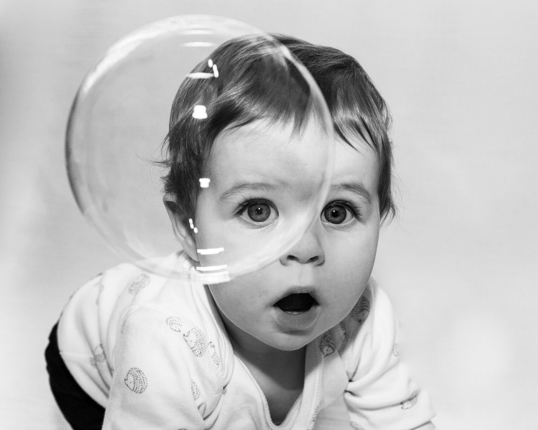 baby with big eyes and a bubble in front of his face taken by Birmingham baby photographer Daniella Staub