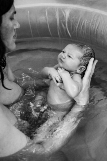 newborn baby with his mother in a home birthing pool